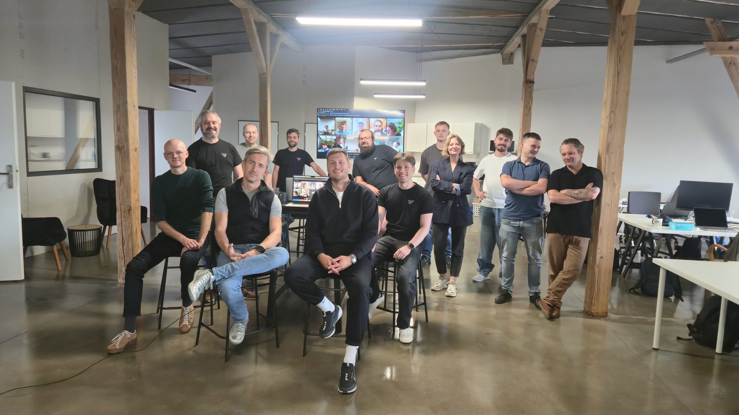 The Vstorm team in the Wrocław office, with remote teammates joining on the screen behind them