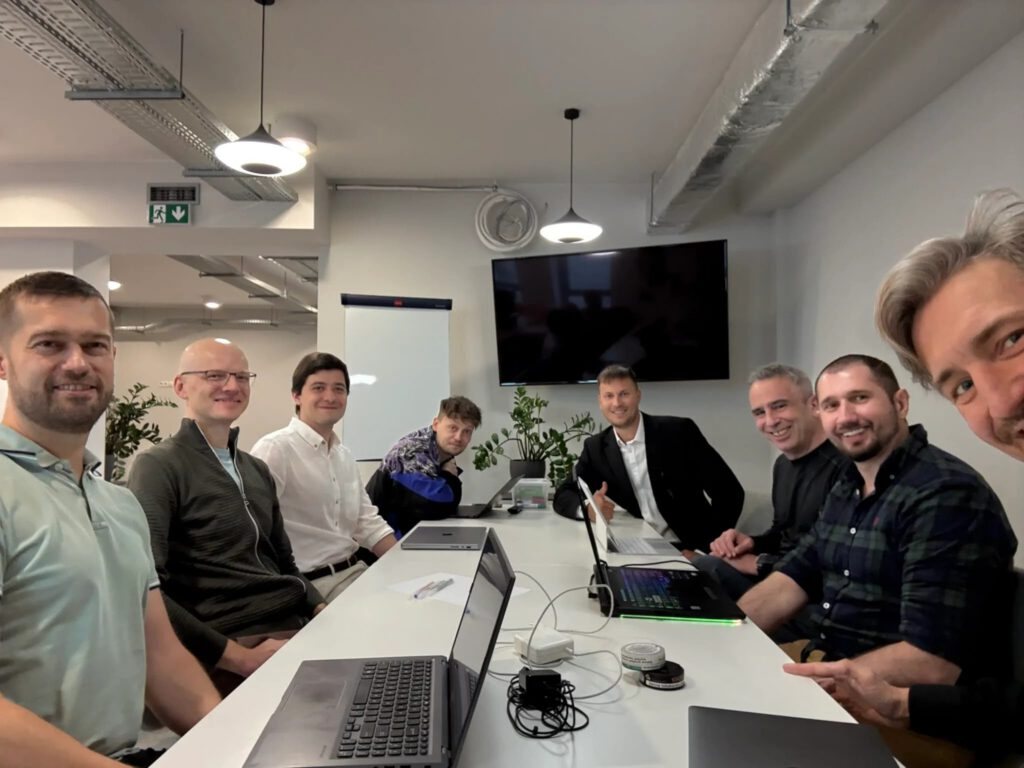 The Vstorm team working together around the table in the office