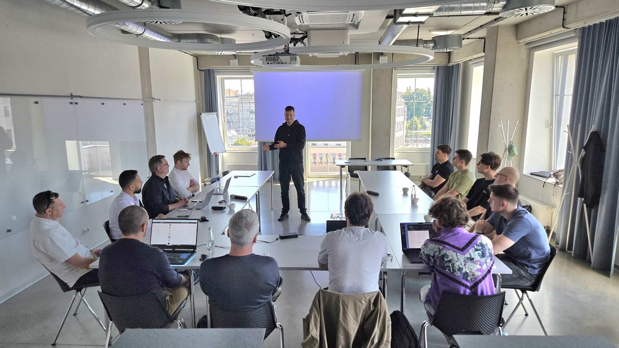 A Vstorm workshop — the team gathered around U-shaped tables during an internal presentation